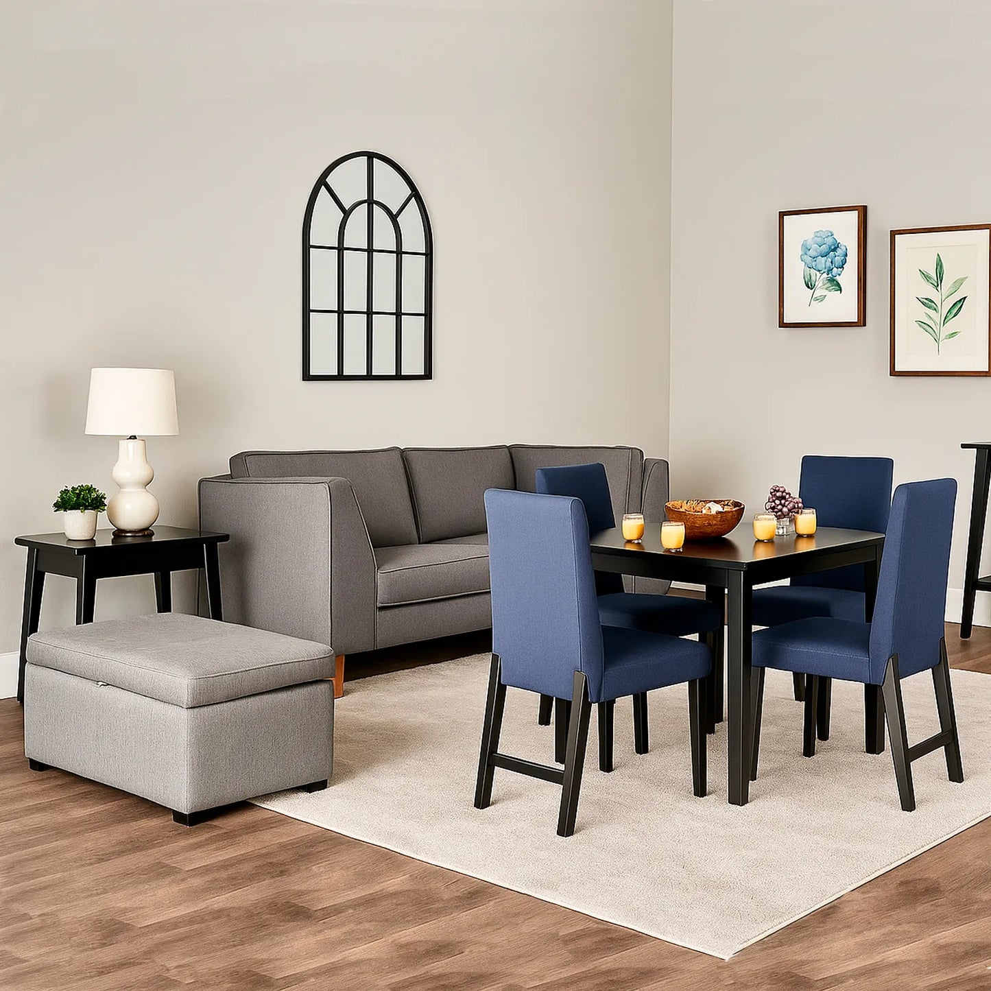 Sofá 3 puestos en tela gris con patas en madera color natural, ubicado en sala moderna con puff tipo baúl color gris, ambientado con comedor de madera en tono negro y sillas tapizadas color azul. Ideal para hogares colombianos que buscan confort y estilo moderno - All Star muebles