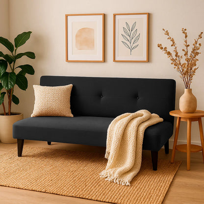 Sofá cama Basic tipo clic clac tapizado en color negro, con patas plásticas en color negro, ubicado en sala moderna minimalista, ambientado con mesa auxiliar, Ideal para hogares colombianos que buscan confort y estilo moderno - All Star muebles