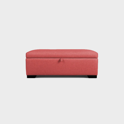 Puff tipo baúl visto de frente, tapizado color salmón, con patas en madera color negro, fotografía sobre fondo blanco, ideal para visualizar la combinación de estilos y colores - All Star muebles