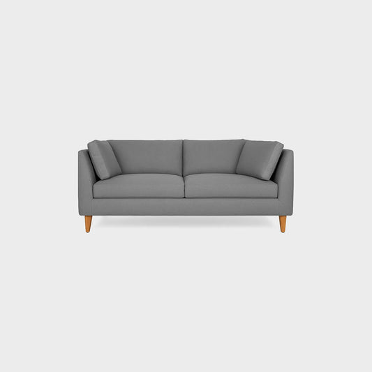 Sofá Gales dos puestos visto de frente, tapizado color gris, con patas en madera torneada tono natural, fotografía sobre fondo blanco, ideal para visualizar la combinación de estilos y colores - All Star muebles